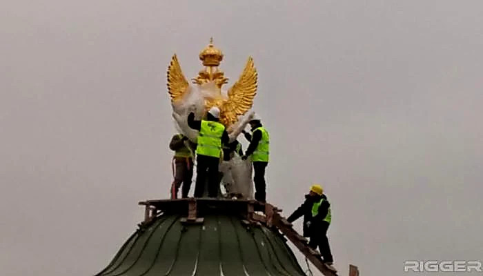 Монтажники устанавливают двуглавого орла на купол телеграфной башни