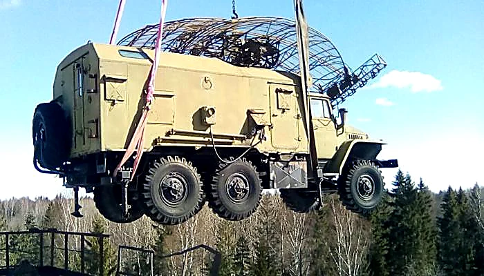 Военная машина поднята краном над лесом